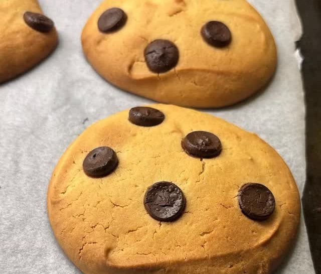Golden chocolate chip cookies on baking paper